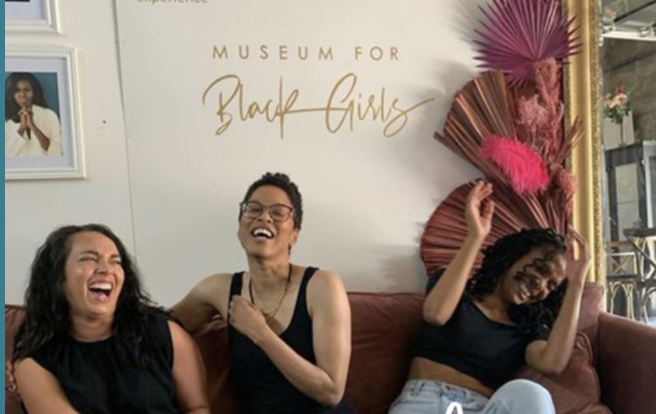 Black women gathered together on a couch inside the Museum for Black Girls